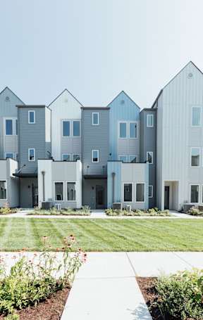 A row of modern houses with grey and white exteriors.