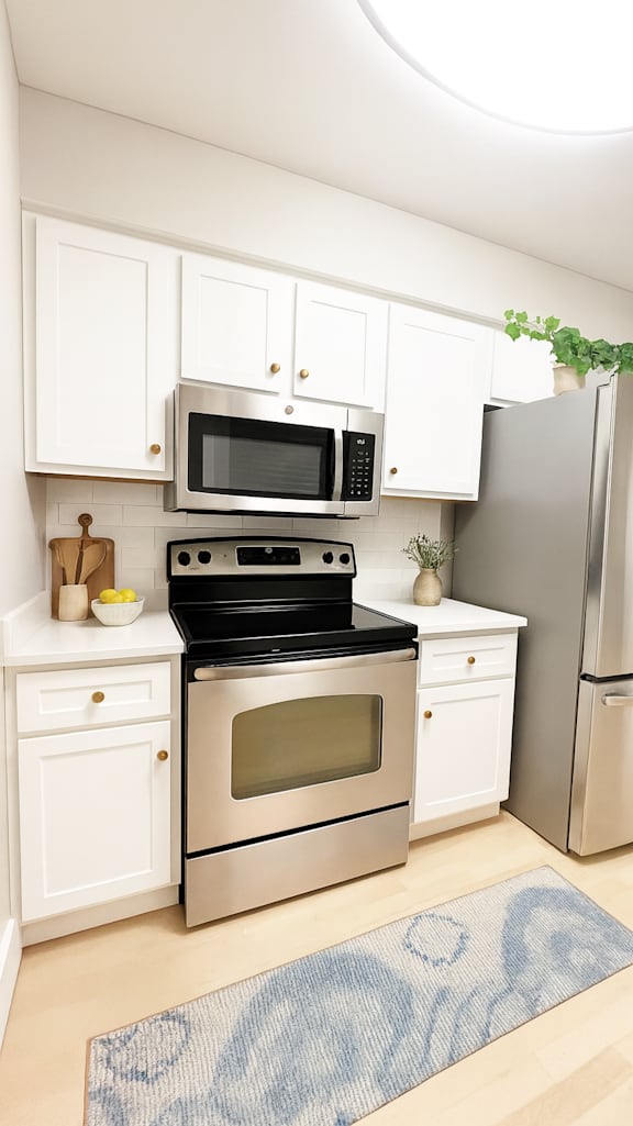 A kitchen with a stove, oven, microwave, and refrigerator.