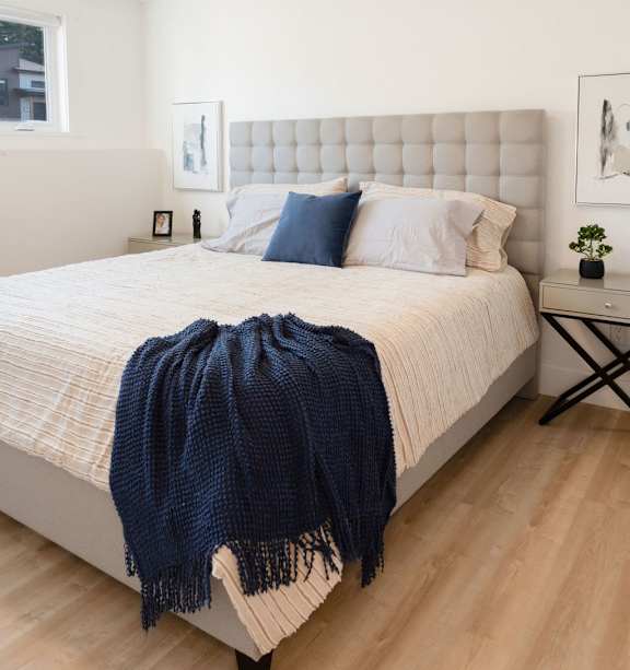 a living room with a dresser and a mirror on the wall