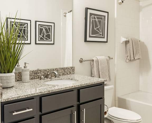 Modern Bathroom with Large Mirror, Granite Counter, and Contemporary Fixtures