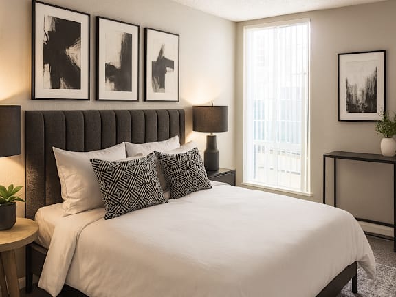 A bedroom with a bed, nightstand, and a painting on the wall.