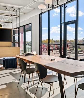 a conference room with a table and chairs and large windows