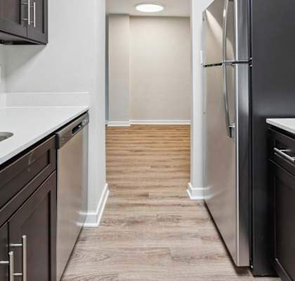 a renovated kitchen with stainless steel appliances and wood flooring