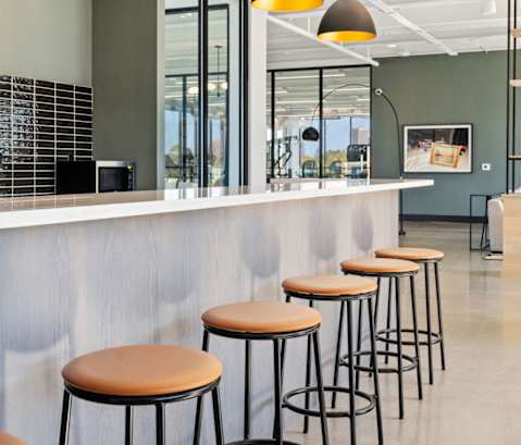 a row of bar stools in front of a counter in a restaurant