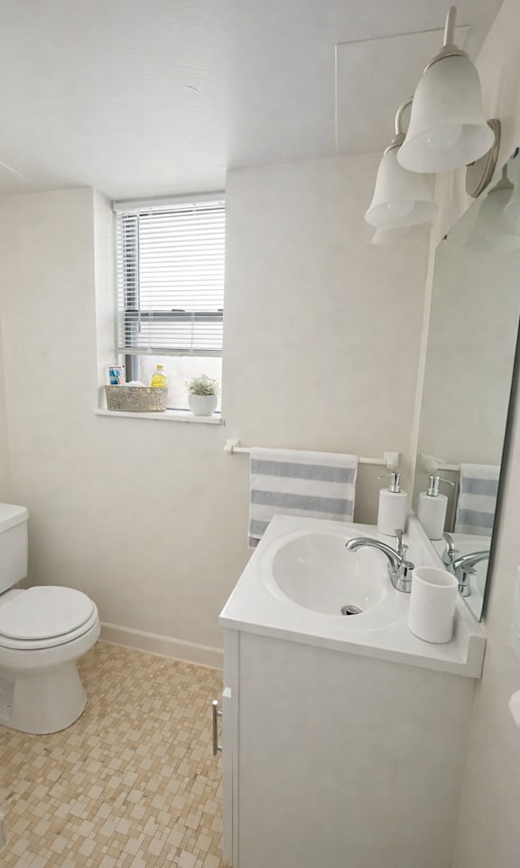 A white toilet sits next to a sink in a small bathroom.