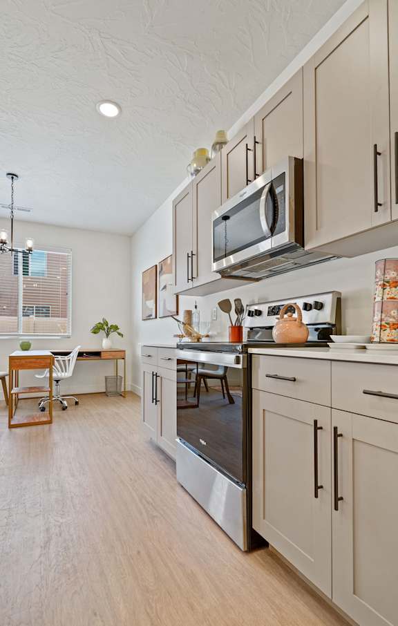 a kitchen with white cabinets and appliances and a table with chairs