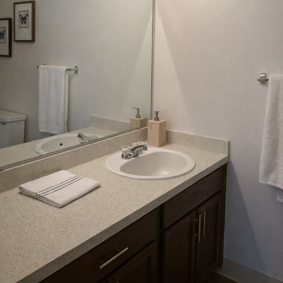 A bathroom with a sink, mirror, and lights.