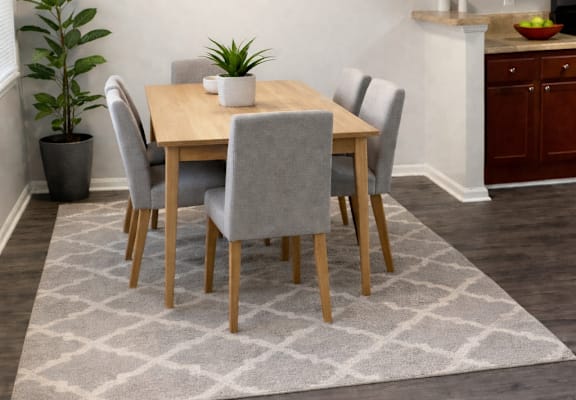 A dining room with a table set for four.