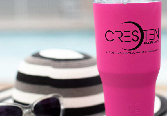 a pink cup and sunglasses on a table
