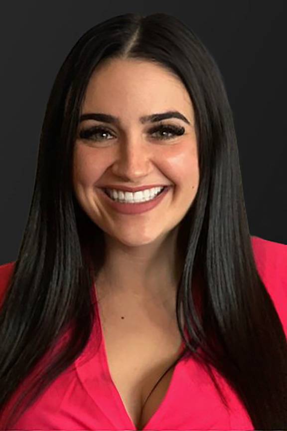 a woman with black hair and a pink shirt is smiling