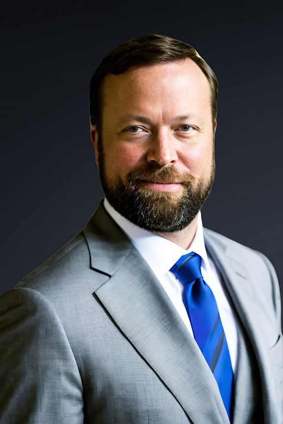 a portrait of a man in a suit and blue tie