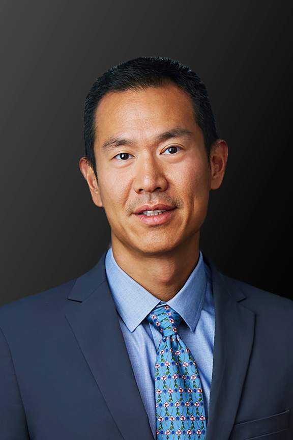 a man wearing a suit and tie and posing for a picture