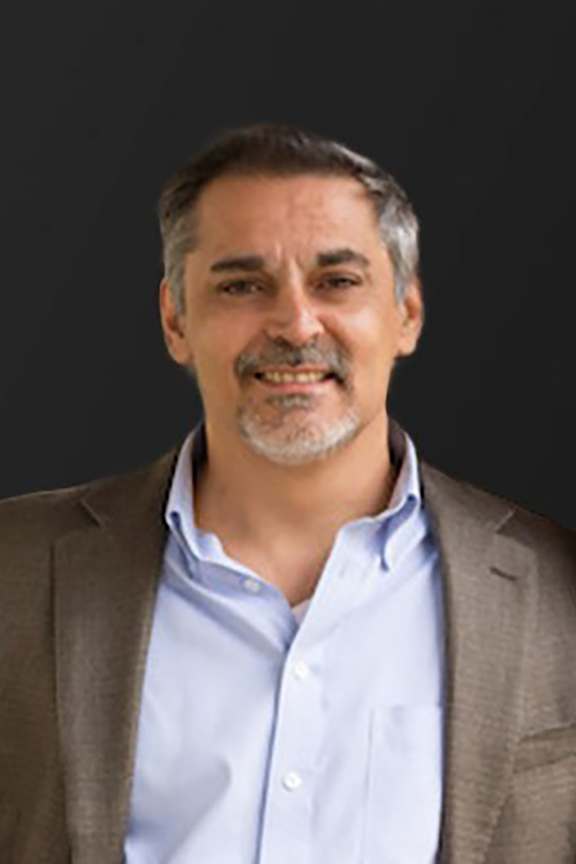 a man wearing a suit and a blue shirt and a brown jacket