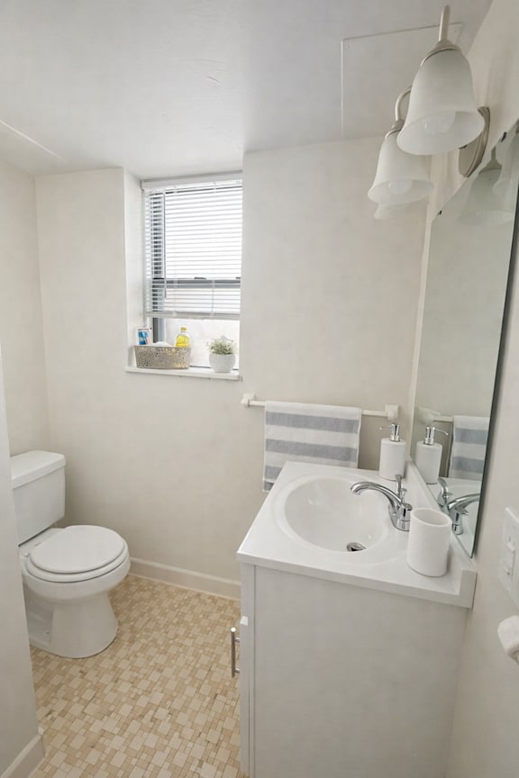 A white toilet sits next to a sink in a small bathroom.