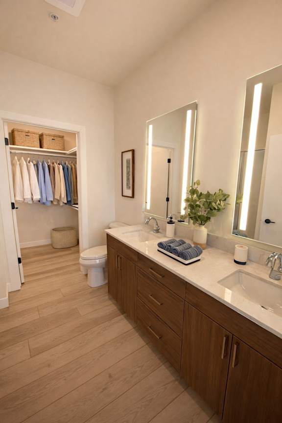 A bathroom with a wooden floor and white walls.