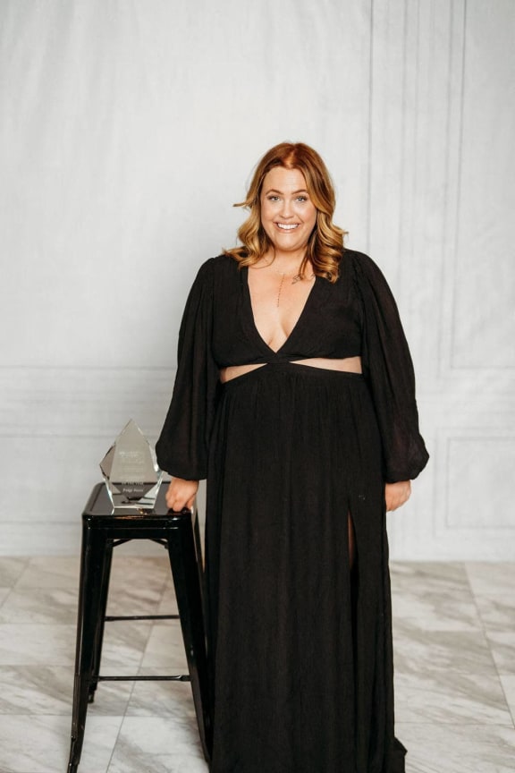 a woman in a black dress standing next to a table