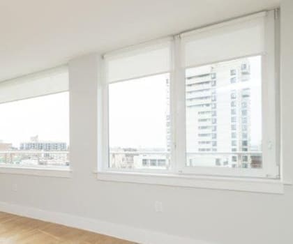 A large empty room with wooden floors and white walls.
