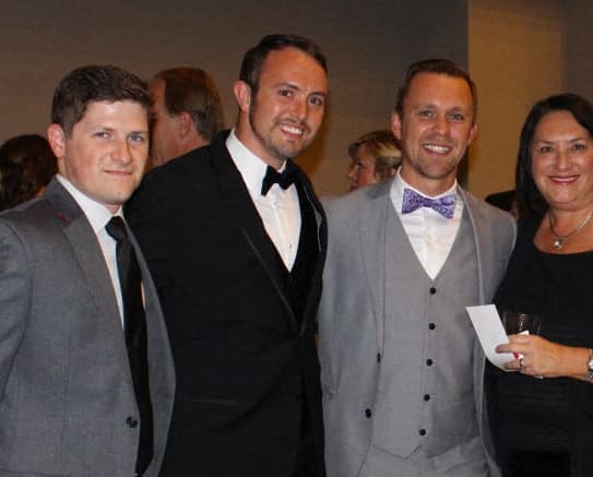 a group of people in suits posing for a picture