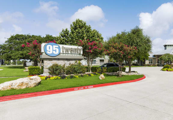 a driveway leading to a building with a sign that says 95twenty