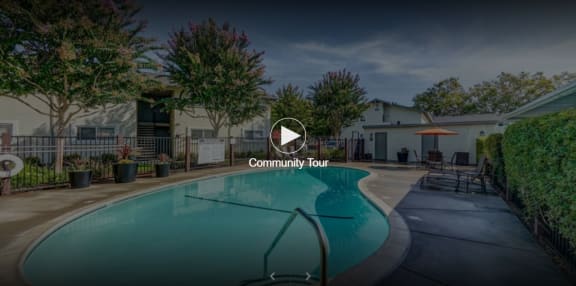 a swimming pool in a yard with a building in the background at Pleasanton Place, Pleasanton