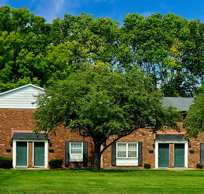 A red brick house with a white door and windows.