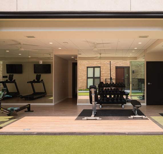 a rendering of a fitness facility with weights and yoga mats in front of a building at One West Drive Apartments, Excelsior, Minnesota