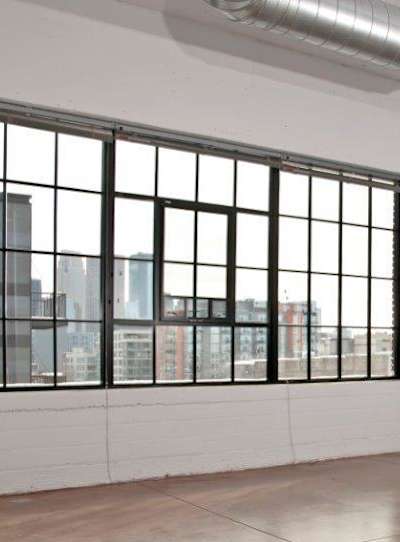 A living room with a chair, a table and pictures on the wall.