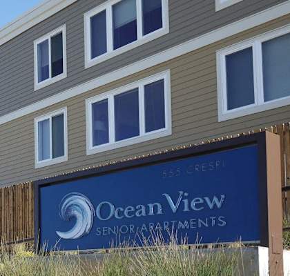 A building with a sign that says Ocean View Senior Apartments.