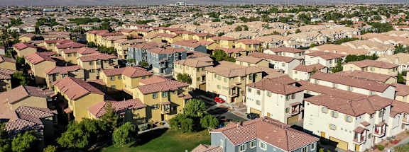 A large suburban neighborhood with houses and mountains in the background.