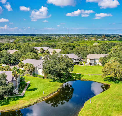 an aerial view of houses next to a body of water