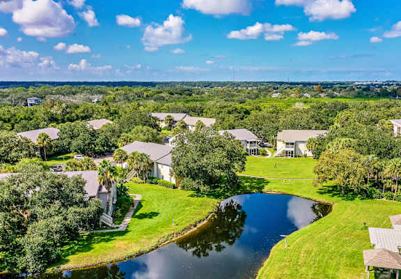 an aerial view of houses next to a body of water