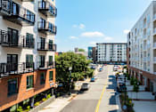 Thumbnail 1 of 10 - A street view of a residential area with cars parked on the side of the road.