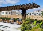 Thumbnail 17 of 22 - A patio with a wooden pergola and green chairs.