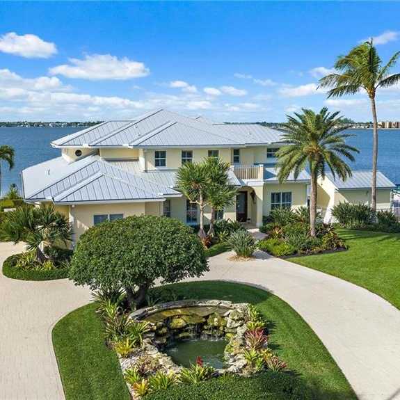 A house with a white roof and a paved walkway in front of it.