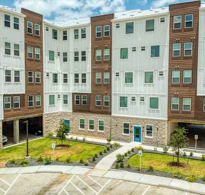 an exterior view of an apartment building with a parking lot