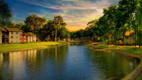 Northlake Apartments Jacksonville, Florida lake between apartment buildings, lush landscaping and trees at sunset
