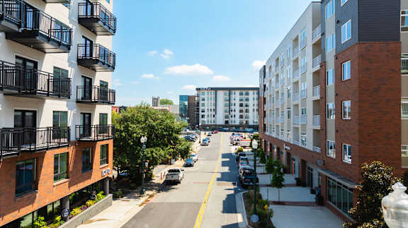 A street view of a residential area with cars parked on the side of the road.