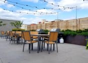 Thumbnail 15 of 22 - A patio with wooden chairs and green tables.