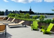 Thumbnail 16 of 22 - A patio with green chairs and a table.
