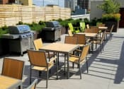 Thumbnail 18 of 22 - A patio with tables and chairs and barbecues.