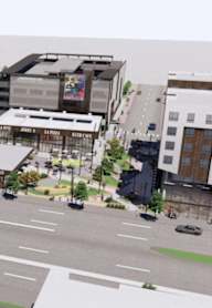 A street view of a city with buildings, cars, and trees.