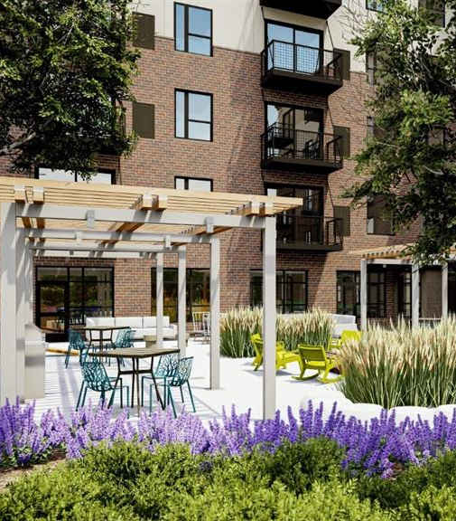 A building with a patio and a pergola at The Bessemer at Seward Commons Apartments, Minnesota, 55404