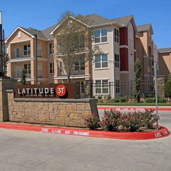 The front sign at Latitude 31, with the apartment building in the background. 