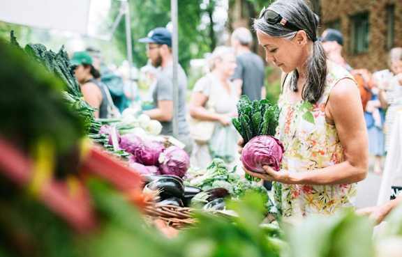 A woman is shopping for fruits at a market.