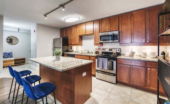 A kitchen with wooden cabinets and a granite countertop.