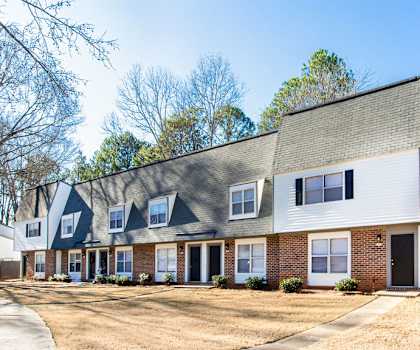 A white house with a grey roof and a black door at Chelsea Place Apartments, Lithonia, Georgia