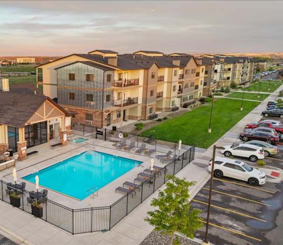 A large apartment complex with a pool in the foreground.