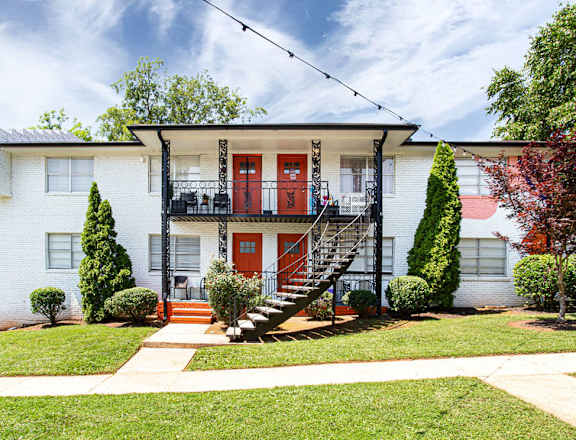 a white house with red doors and a black staircase  at The Oasis on Cascade, Atlanta, 30310