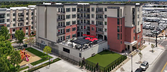A large building with a red awning in front of a mountain range.
