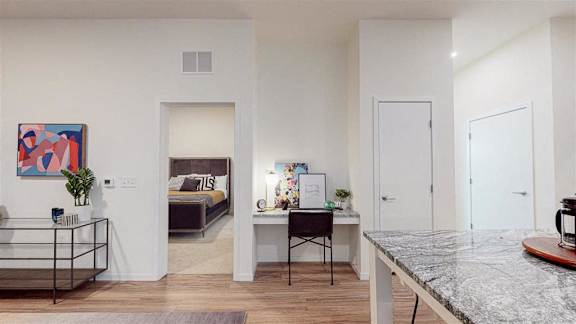 A modern living room with a large painting on the wall and a marble countertop at The Bessemer at Seward Commons Apartments, Minneapolis, Minnesota